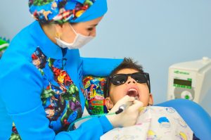 Look how cool that dentist is, with all those comic book characters on her and shades for the kid? So cool. COOL.